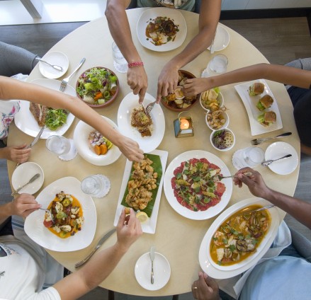  People eating food around a table at Agua Cayman 