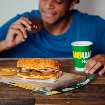  Man at Subway eating s Sandwich, cookie and drinking 